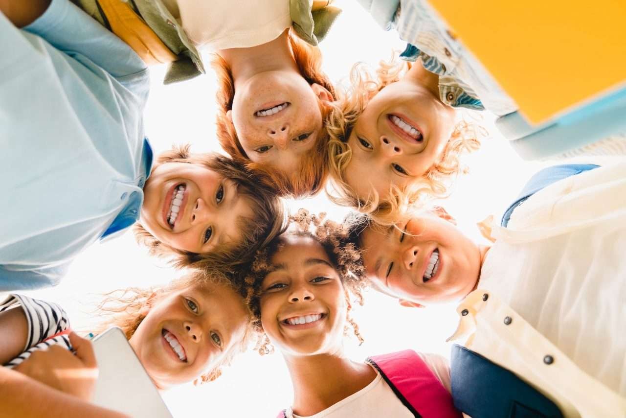 low-angle-view-of-a-group-of-mixed-race-multi-ethnic-classmates-schoolchildren-standing-in-round.jpg